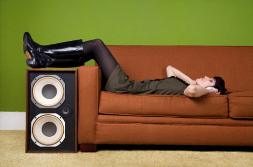 Women listening to headphones on couch