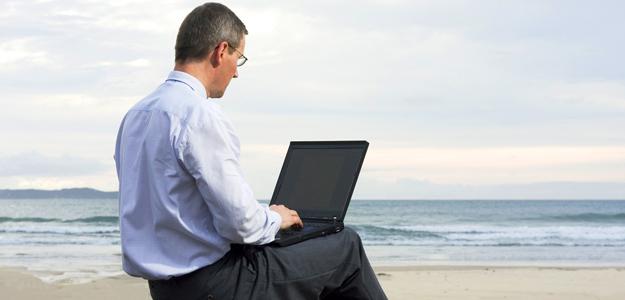 using laptop on beach vacation