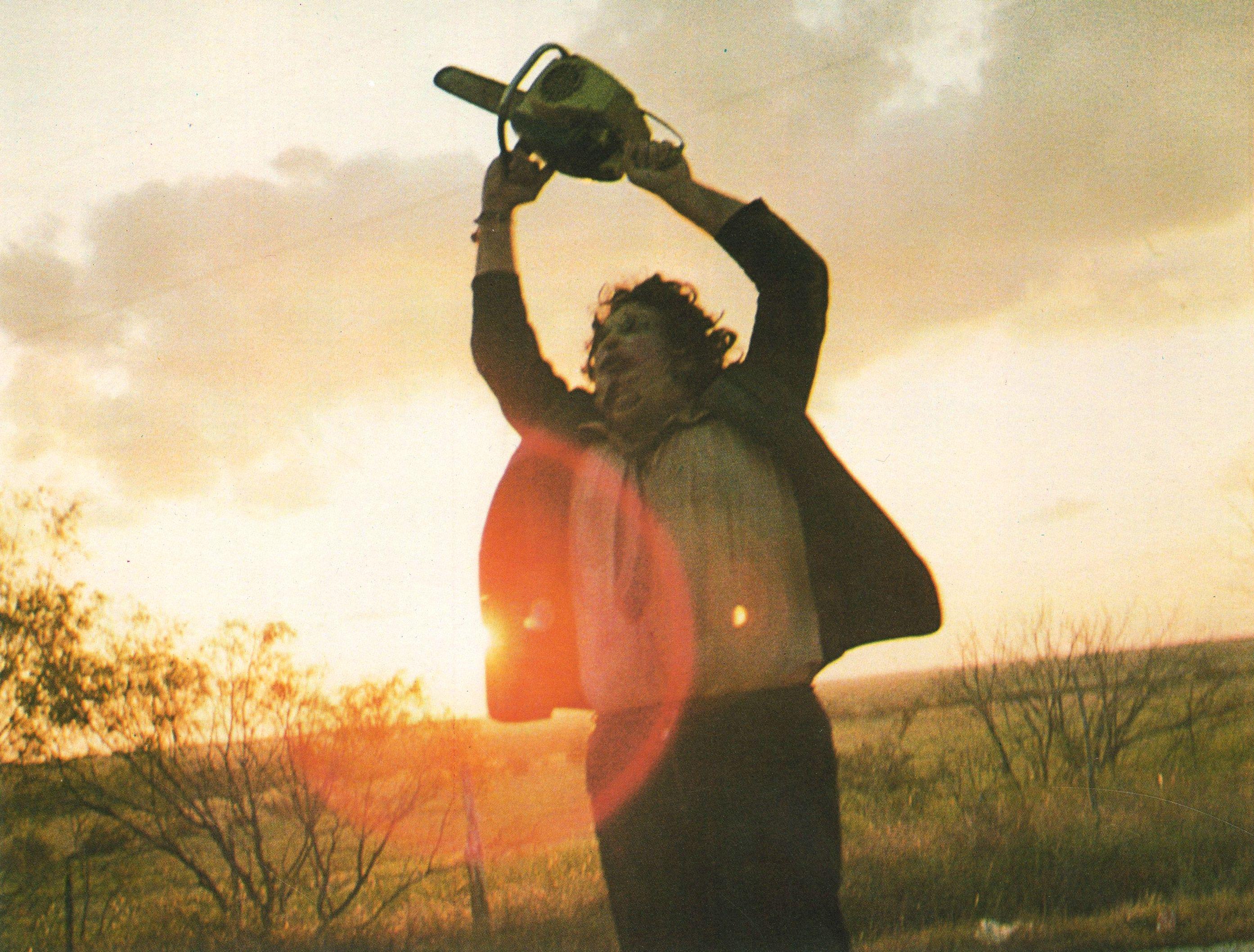 Leatherface wielding.a chainsaw in a field on Texas Chainsaw Massacre.