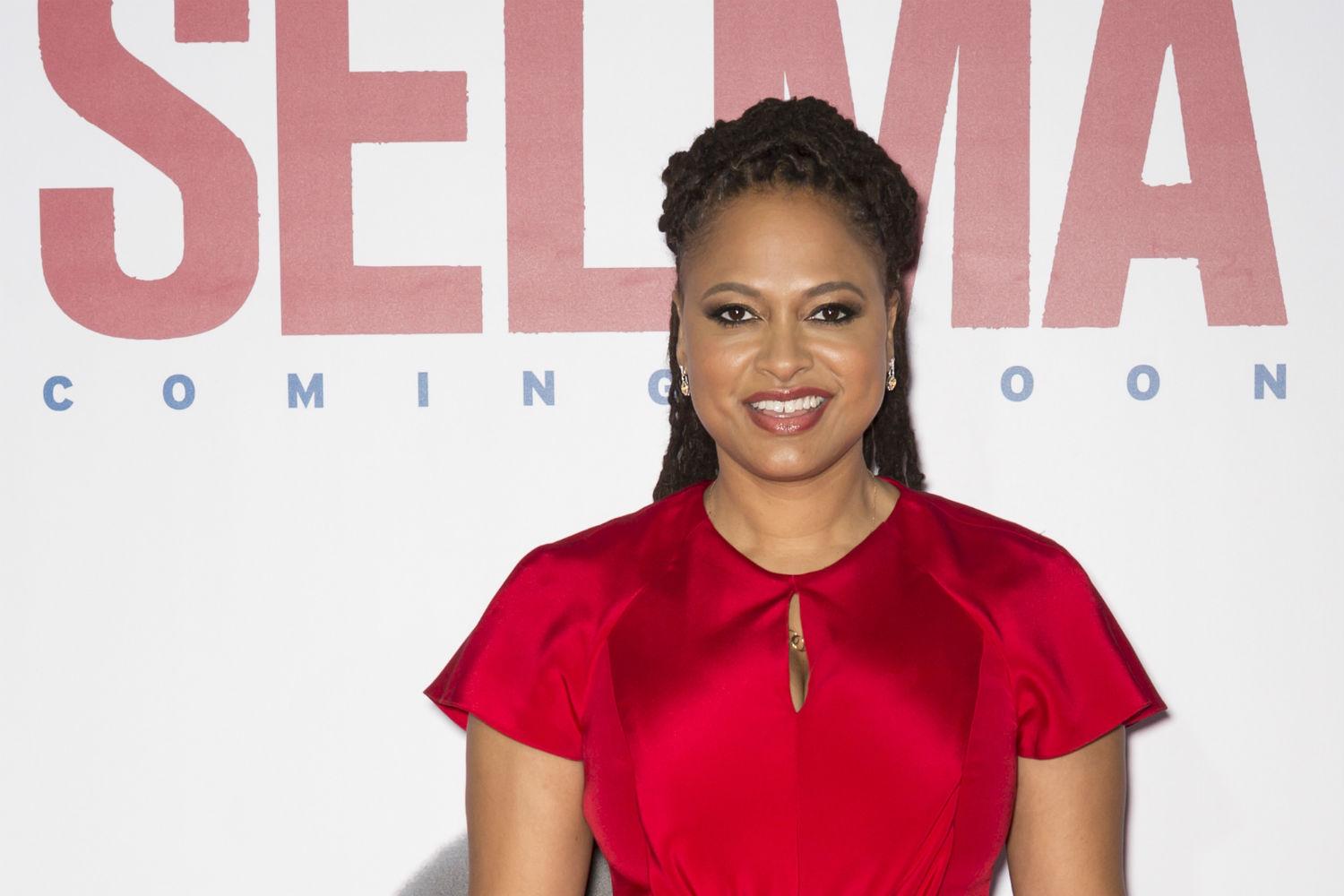 Director Ava DuVernay standing in front of a banner for "Selma."