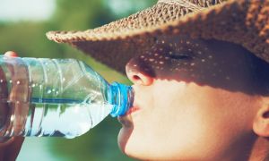 stanford cooling textile 46616588  woman drinking water in summer sunlight