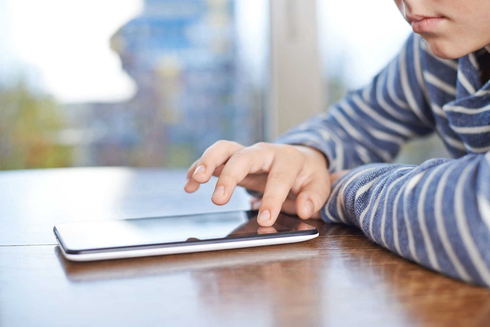 ipad equals sedative before child surgery 12 years old children boy sitting at the wooden desk while playing with tablet pad 