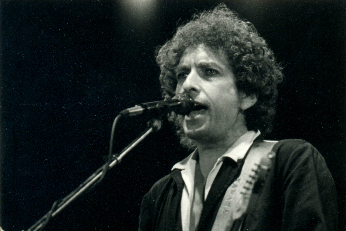 Bob Dylan sings into a microphone.