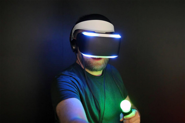 A man playing with a PS VR headset and Move controllers.