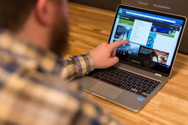 Man using Chromebook touchscreen.