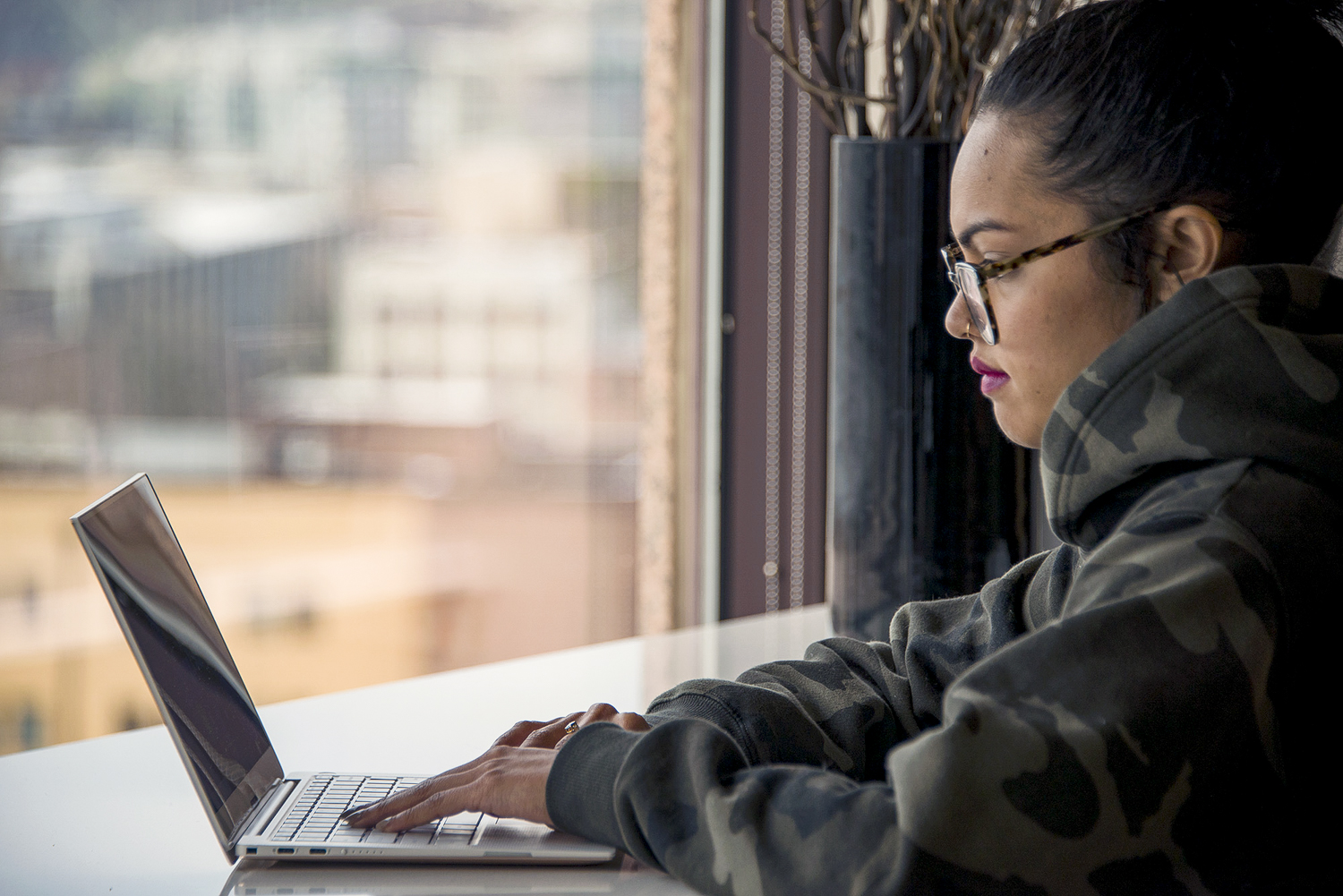 Dell XPS 13 9370 review | Hero shot from the side of young woman using the laptop