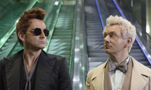 The two main characters from Good Omens looking at one another, one in a black suit, one in white.