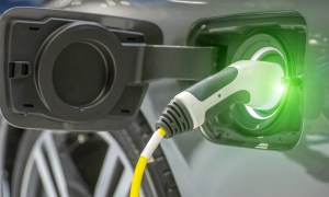 Close up of the Hybrid car electric charger station with power supply plugged into an electric car being charged.