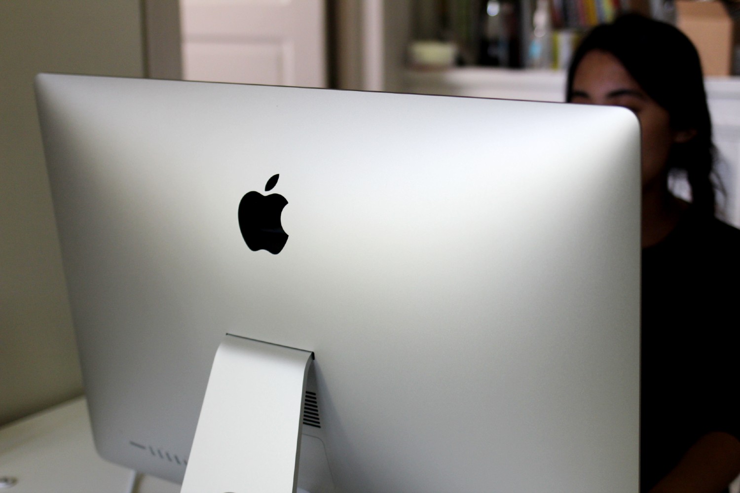 The back of a silver iMac in an office.