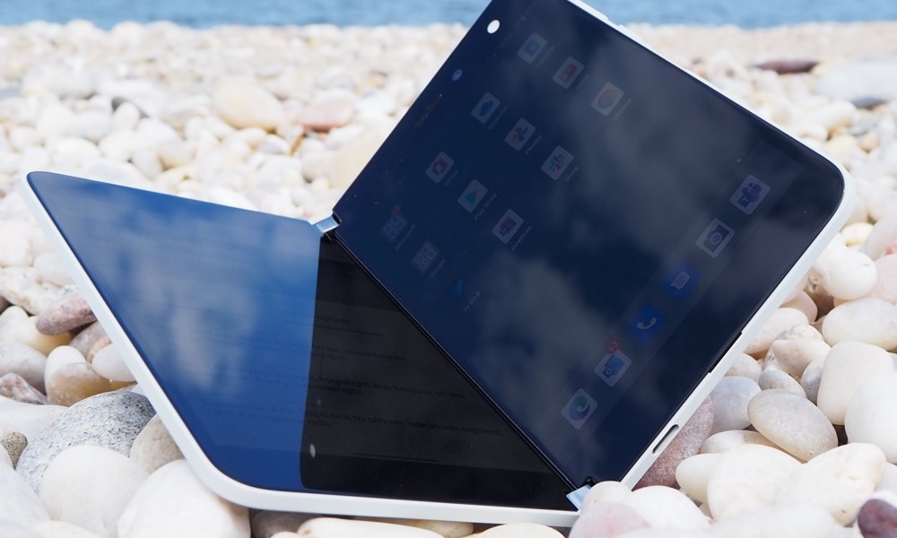 The Microsoft Surface Dup foldable smartphone placed on pebbles.