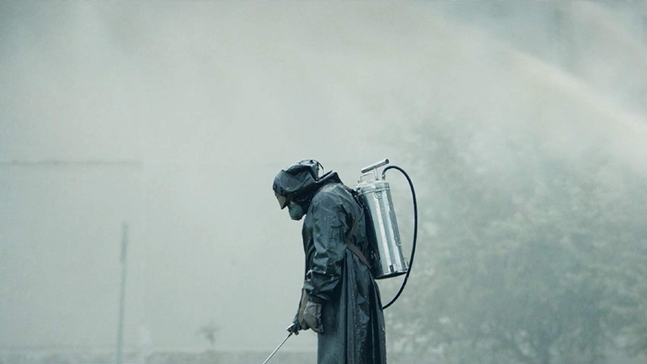 A man in a hazmat suit sprays the ground in Chernobyl.