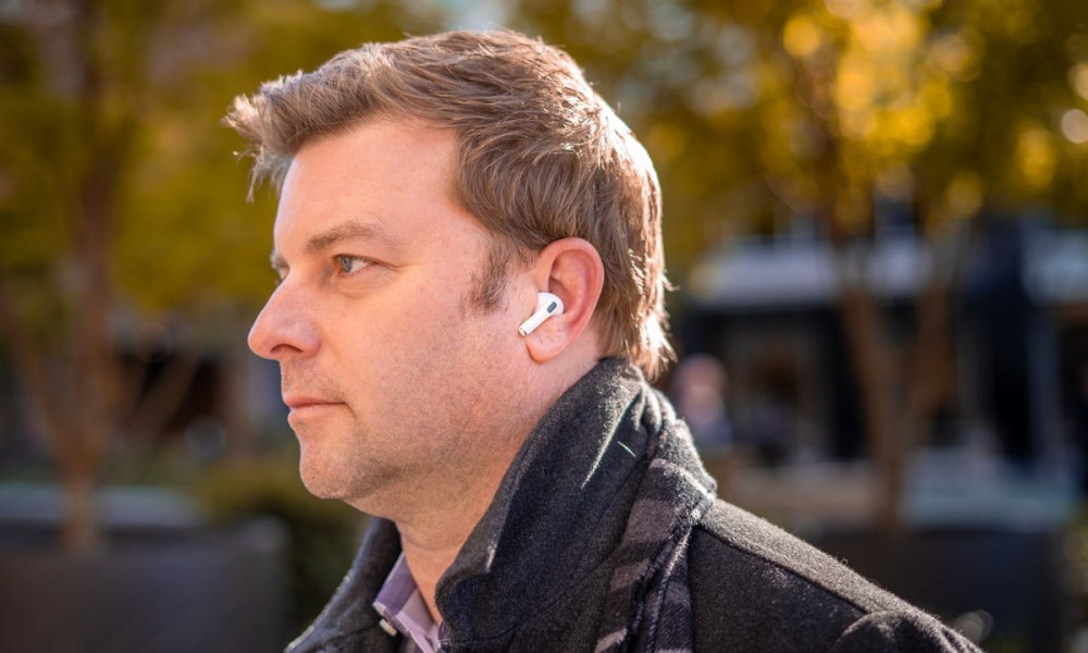 Man wearing Apple AirPods Pro outdoors.