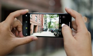 A person holding an iPhone while taking a Live Photo.