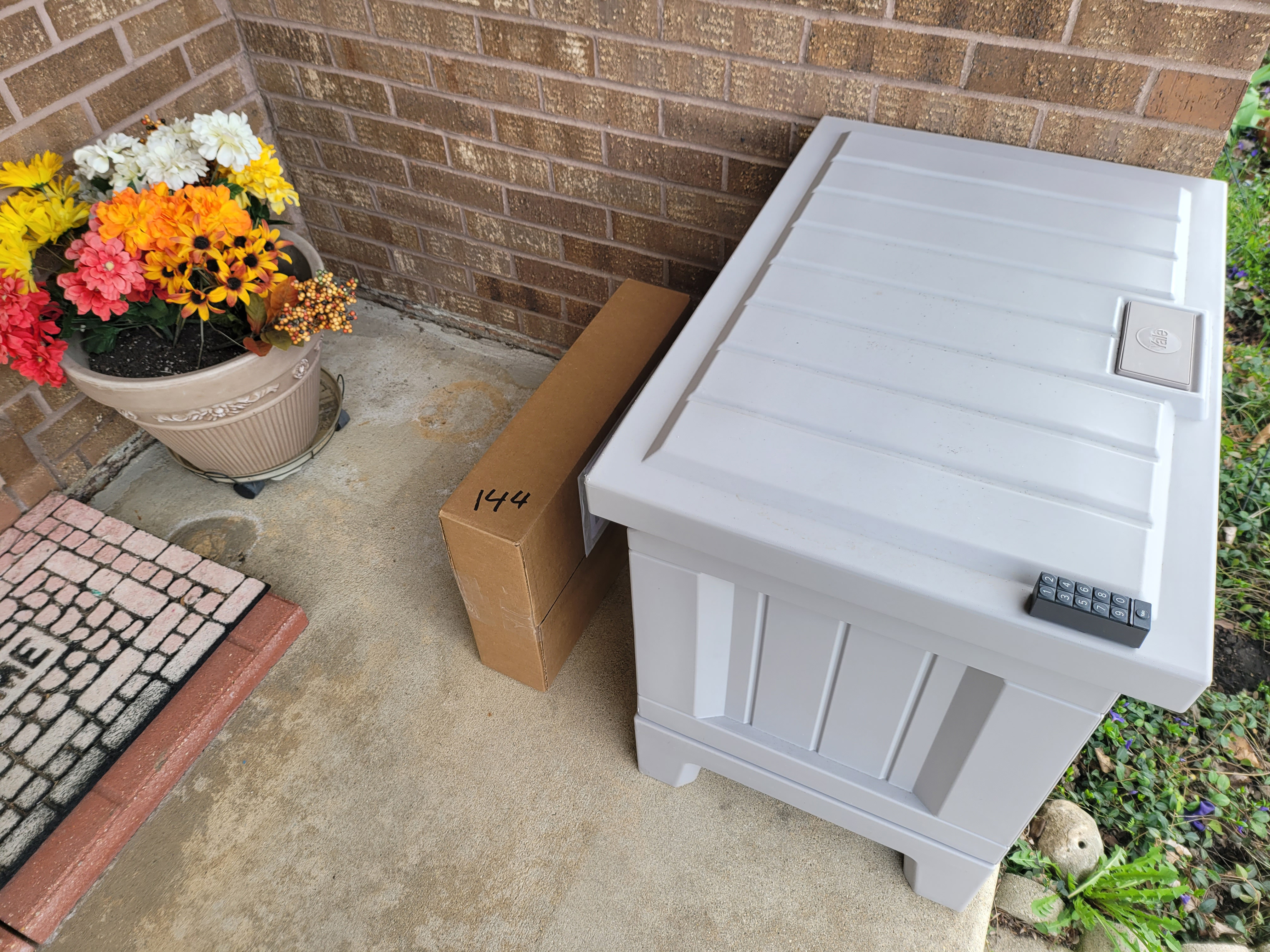 A package sits behind the Yale Smart Delivery box.