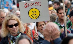 an anti-5G protestor holing a sign