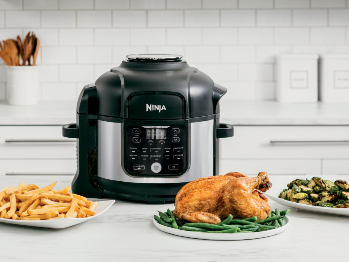 Ninja Foodi 11-in-1 6.5-quart Pro Pressure Cooker + Air Fryer with Stainless finish on counter with cooked chicken.