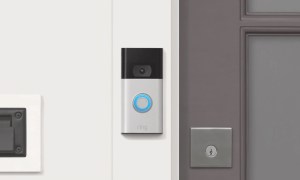 The Ring Video Doorbell in Satin Nickel, installed beside a doorway.