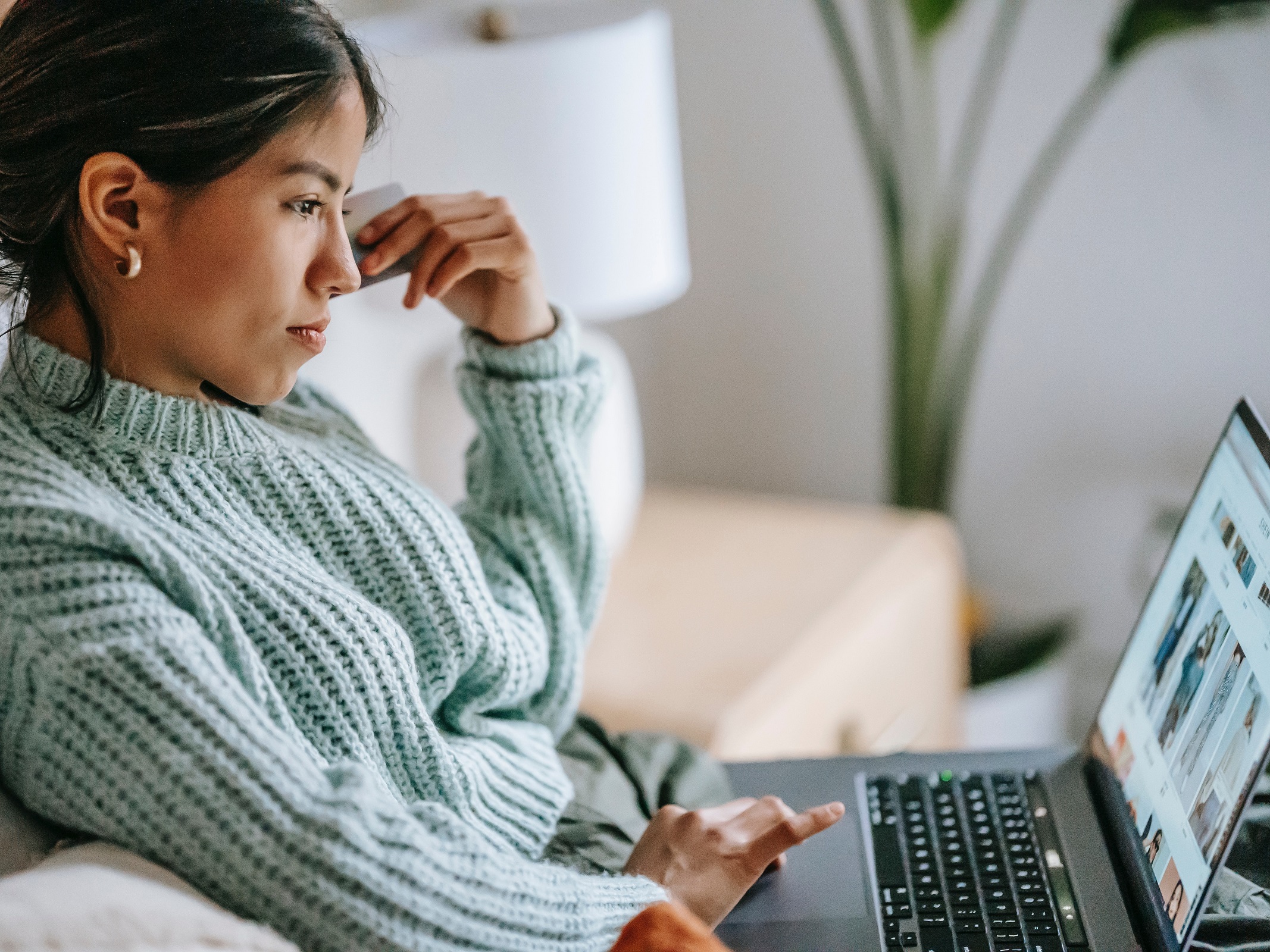 Woman shopping online using a laptop protected by McAfee Total Protection.