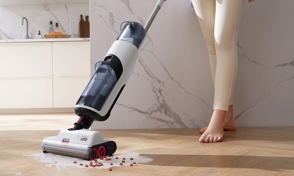 A Roborock Dyad cleans up spilled cereal on a hardwood floor.