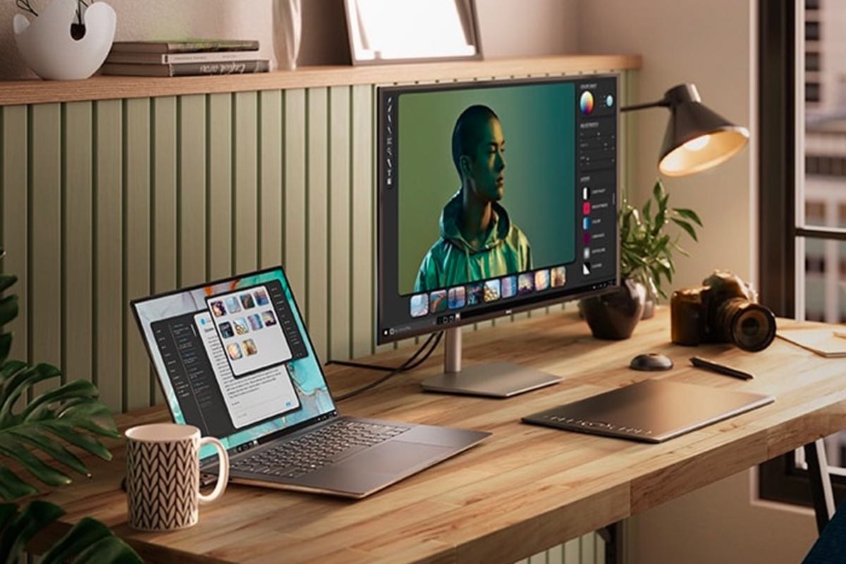 A Dell XPS 15 Touch Laptop sits on an office desk next to an external monitor.