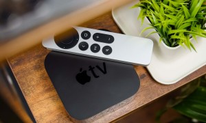 An Apple TV 4K set-top box and remote control sit on a media stand.