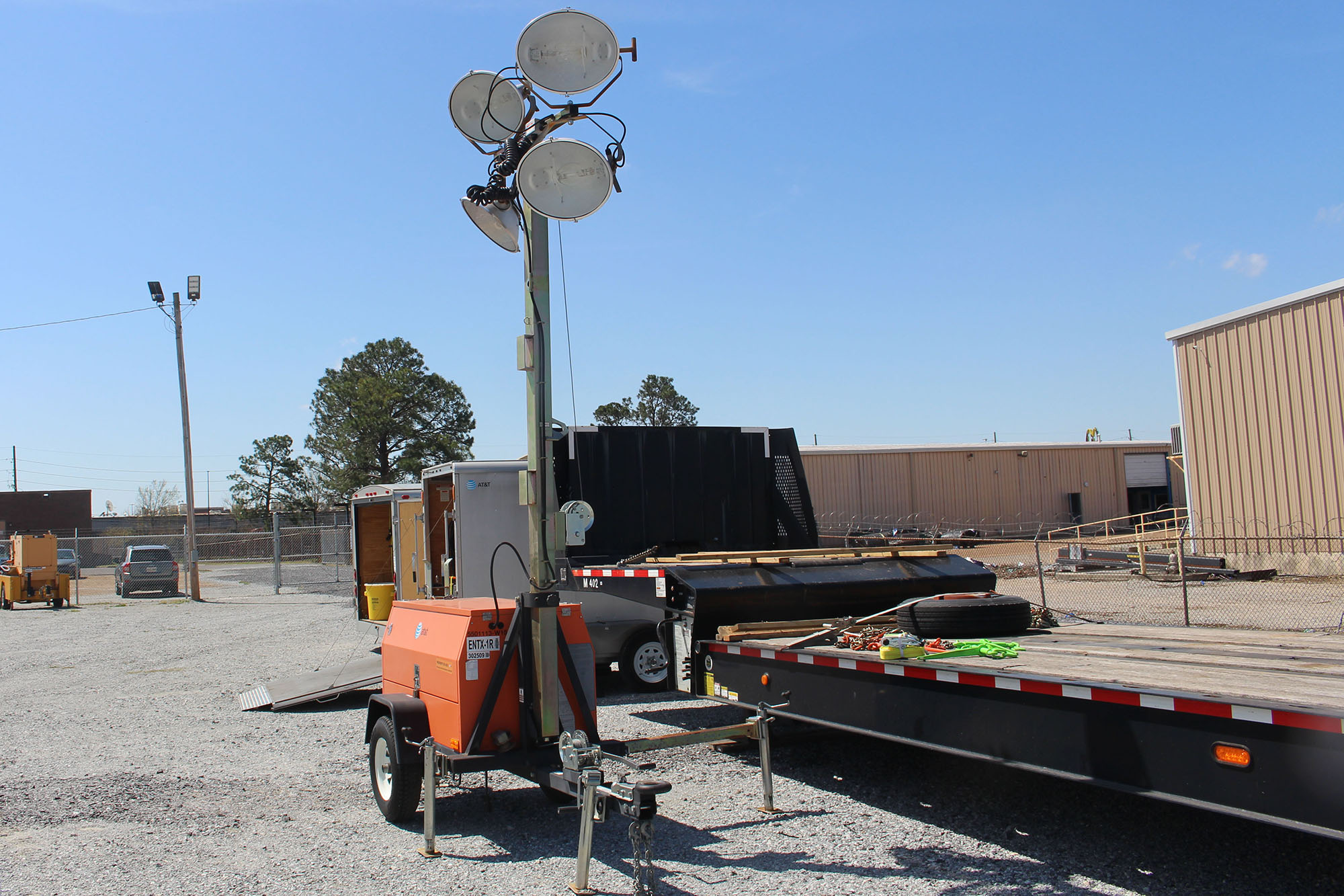 A portable lighting setup next to a flatbed truck.