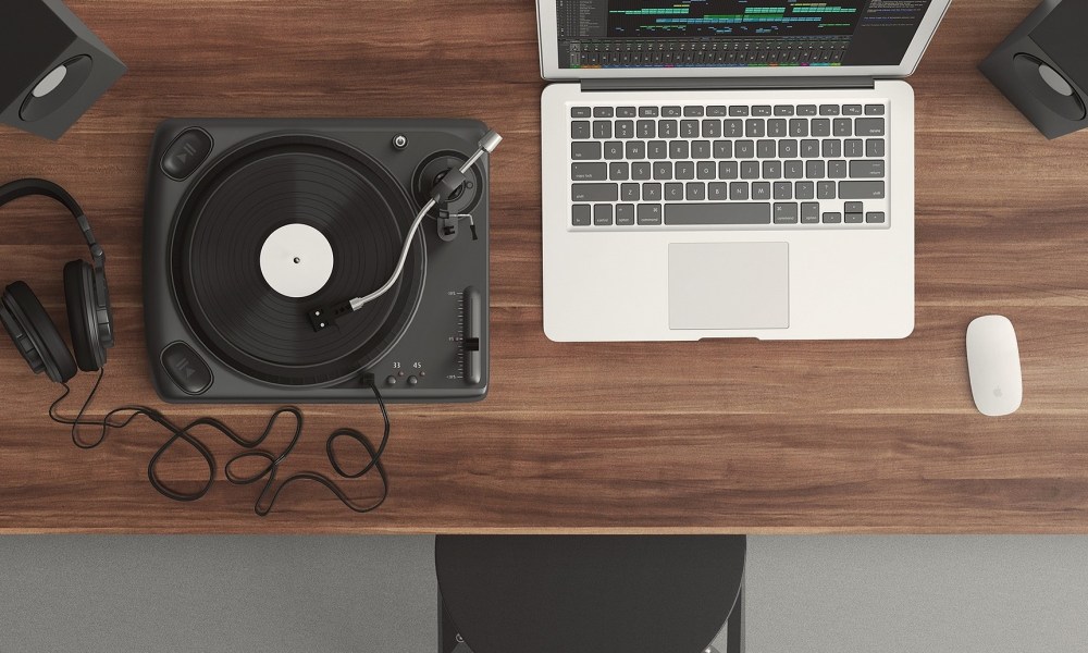 Computer on a desk with a turnable and headphones.