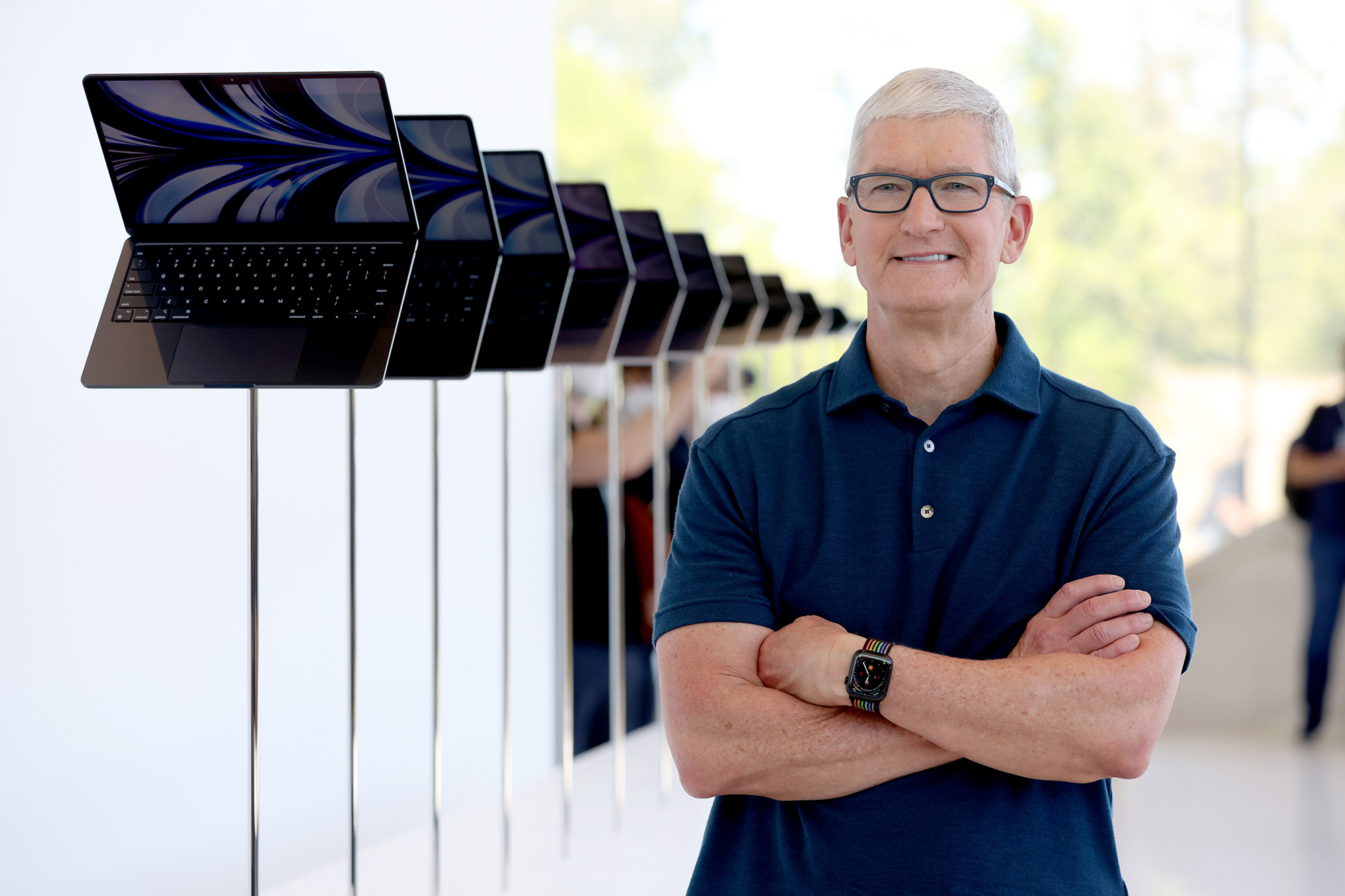 Apple CEO Tim Cook looks at a display of brand new redesigned MacBook Air laptop during the WWDC22