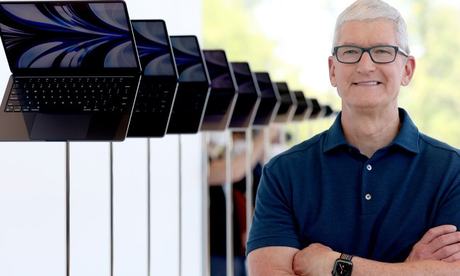 Apple CEO Tim Cook looks at a display of brand new redesigned MacBook Air laptop during the WWDC22