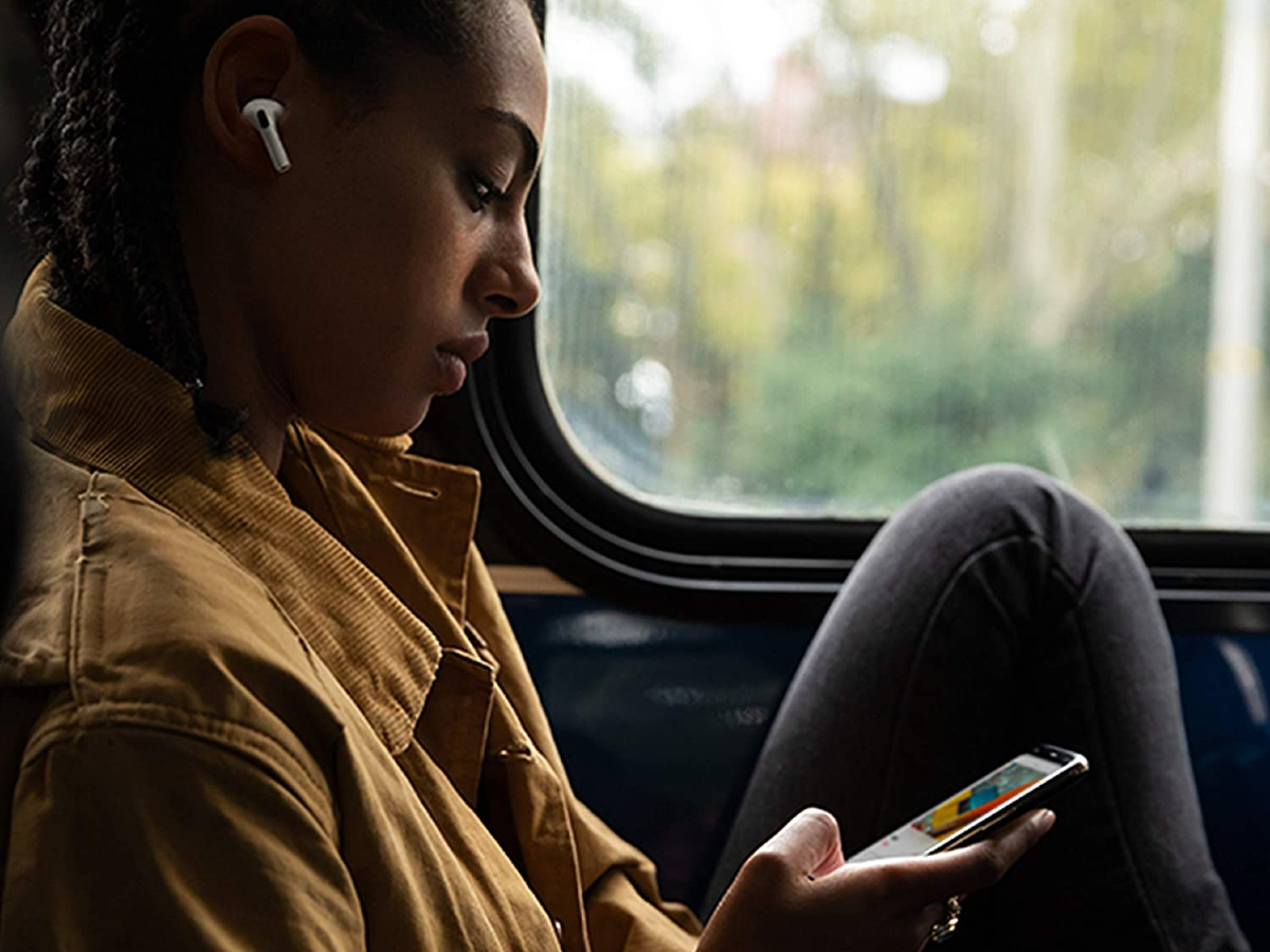 airpods pro deal amazon july 2022 woman wearing wireless earbuds on a train