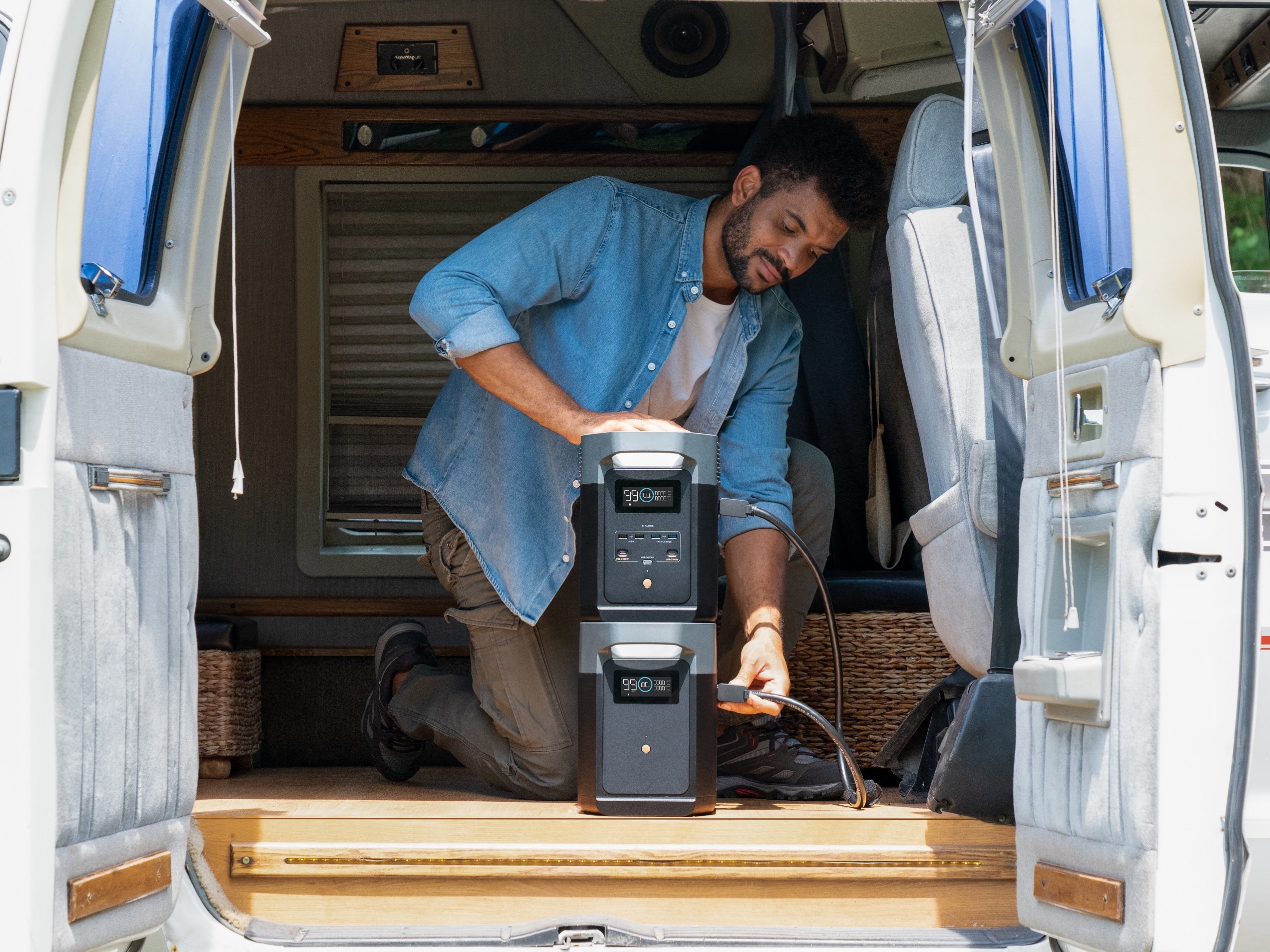 Man setting up EcoFlow DELTA 2 in van for off-grid living.