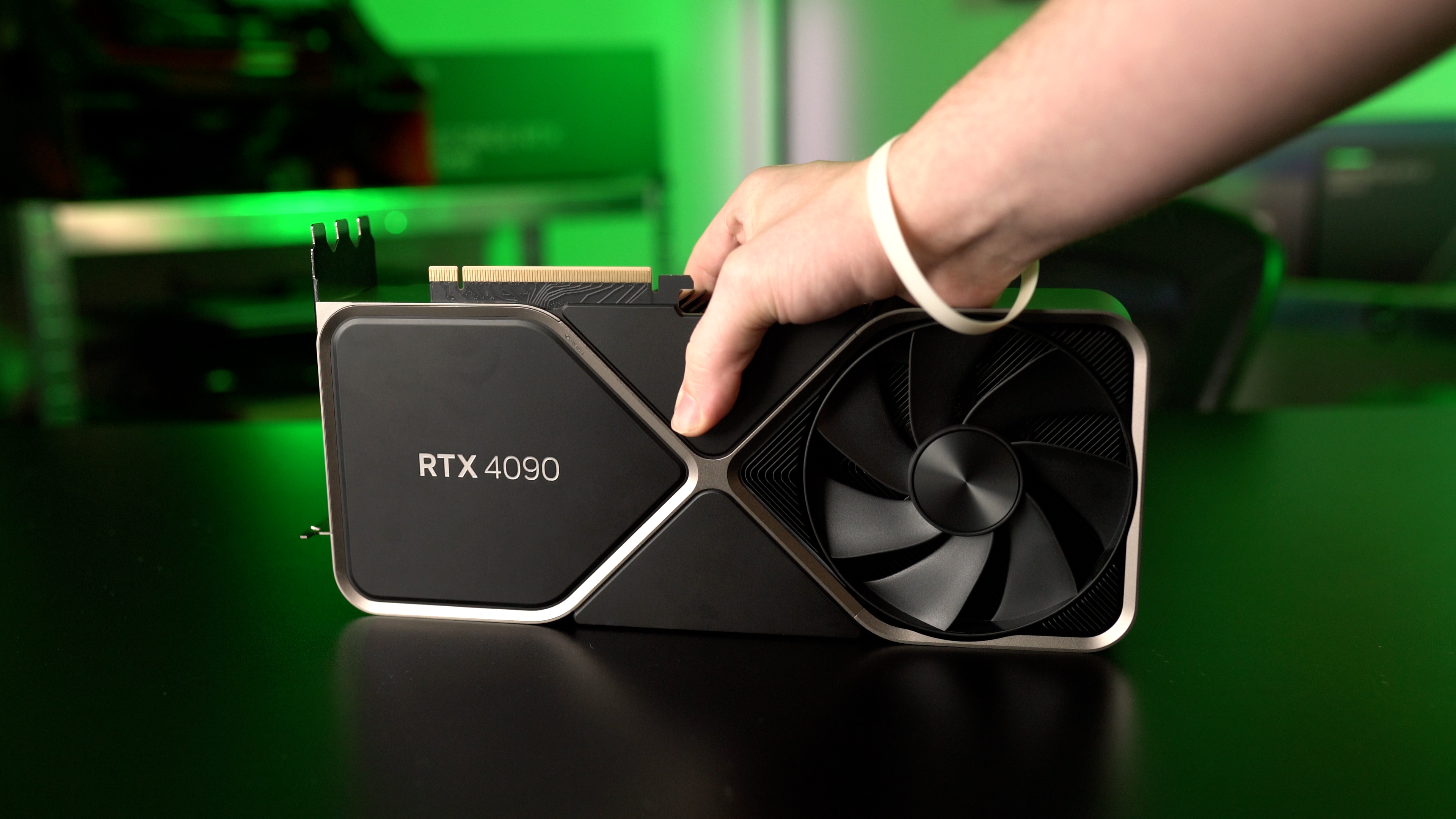 A hand holding the RTX 4090 GPU.