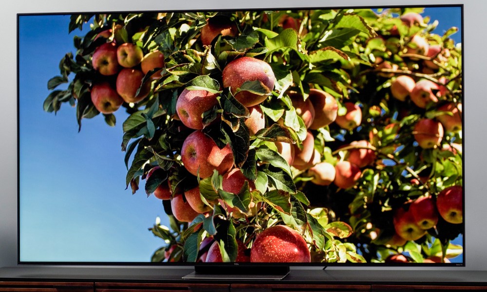 TCL 6-Series TV displaying colorful image of an apple tree against a blue sky background.