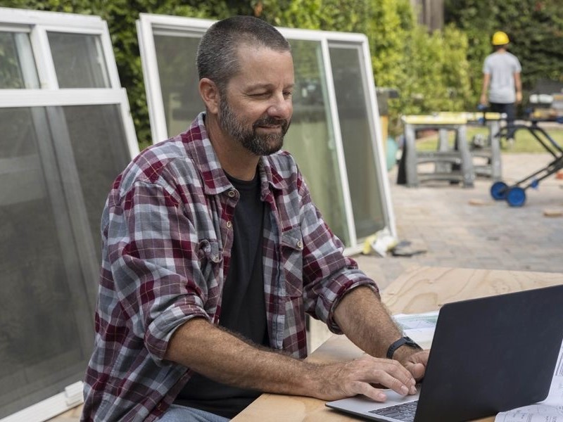 A man using QuickBooks software on a laptop.