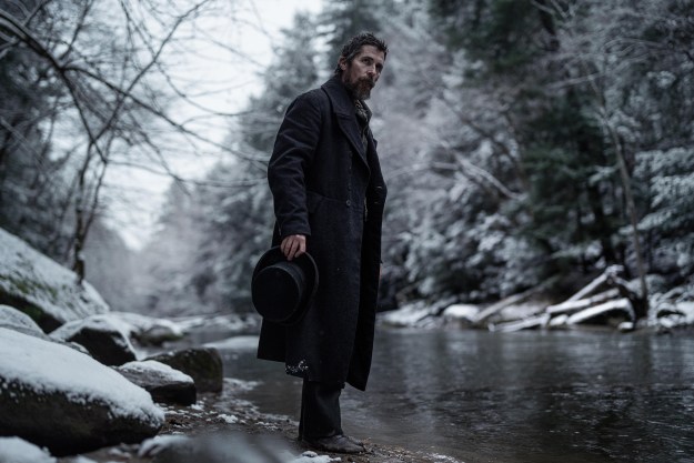 Christian Bale stands near a river in The Pale Blue Eye.