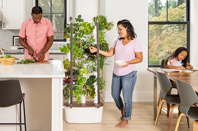 The MyGardyn being used in a kitchen by a family.