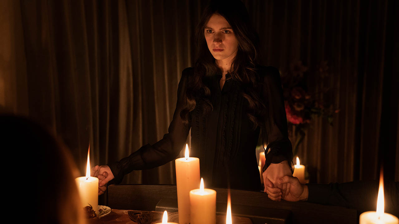 A first look image from Servant season 3 on Apple TV+ of Leanne holding hands with others out of view, surrounded by candles.