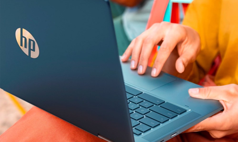 A woman uses the trackpad of the HP 14-inch 2-in-1 touch laptop.