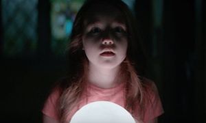 A young girl holding a lamp and looking scared in the movie The Boogeyman.