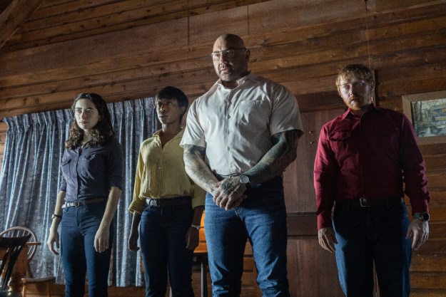 Abby Quinn, Nikki Amuka-Bird, Dave Bautista, and Ruprt Grint stand grimly inside a cabin, staring at the camera.