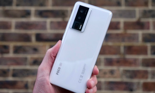 A person holding the Poco F5 Pro and showing the back.