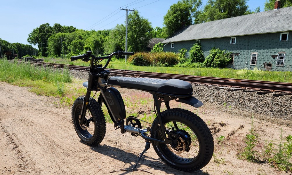 Super73-S Adventure parked by railroad tracks.