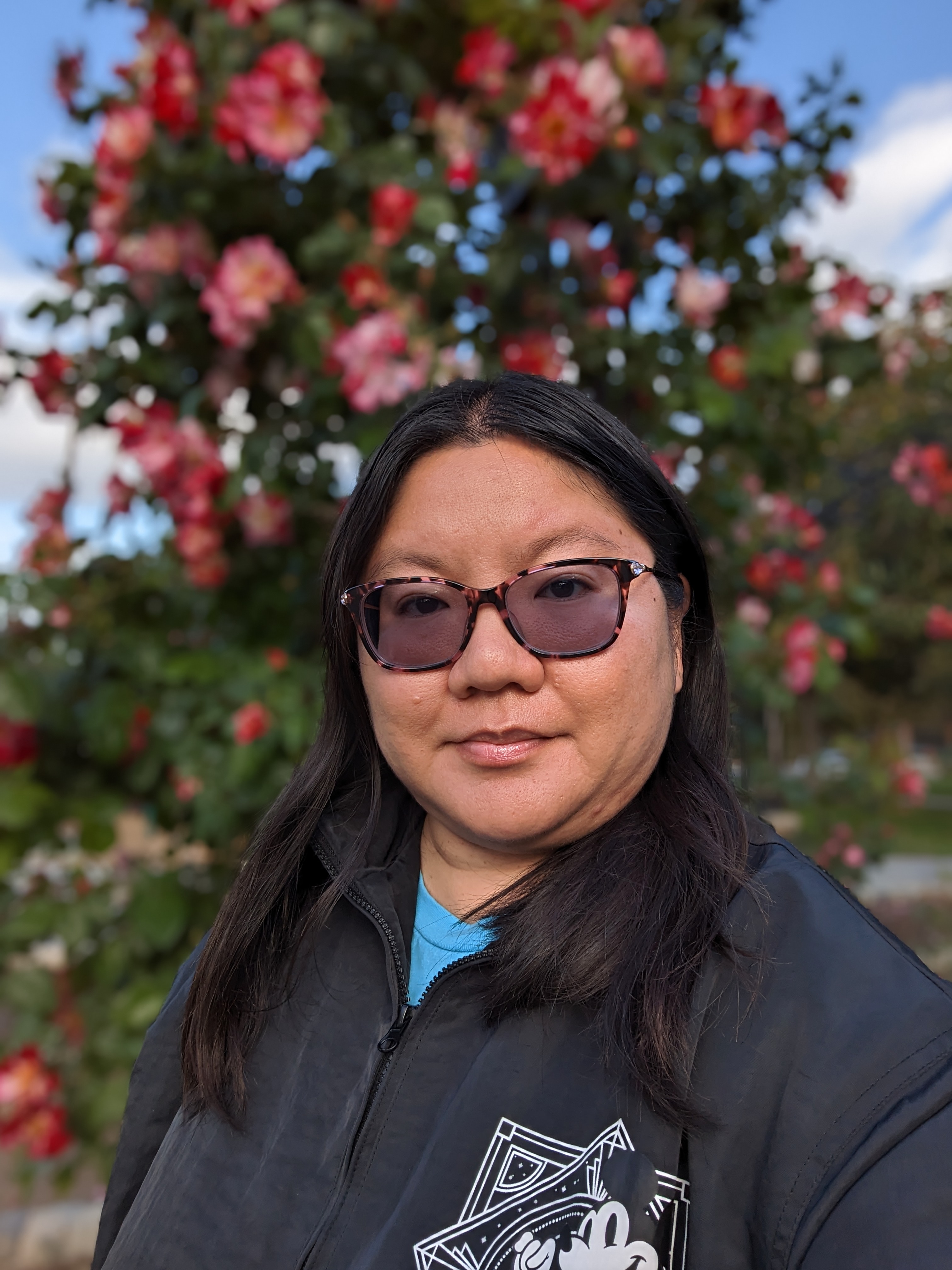 Portrait selfie in front of rose garden taken with Google Pixel 7a