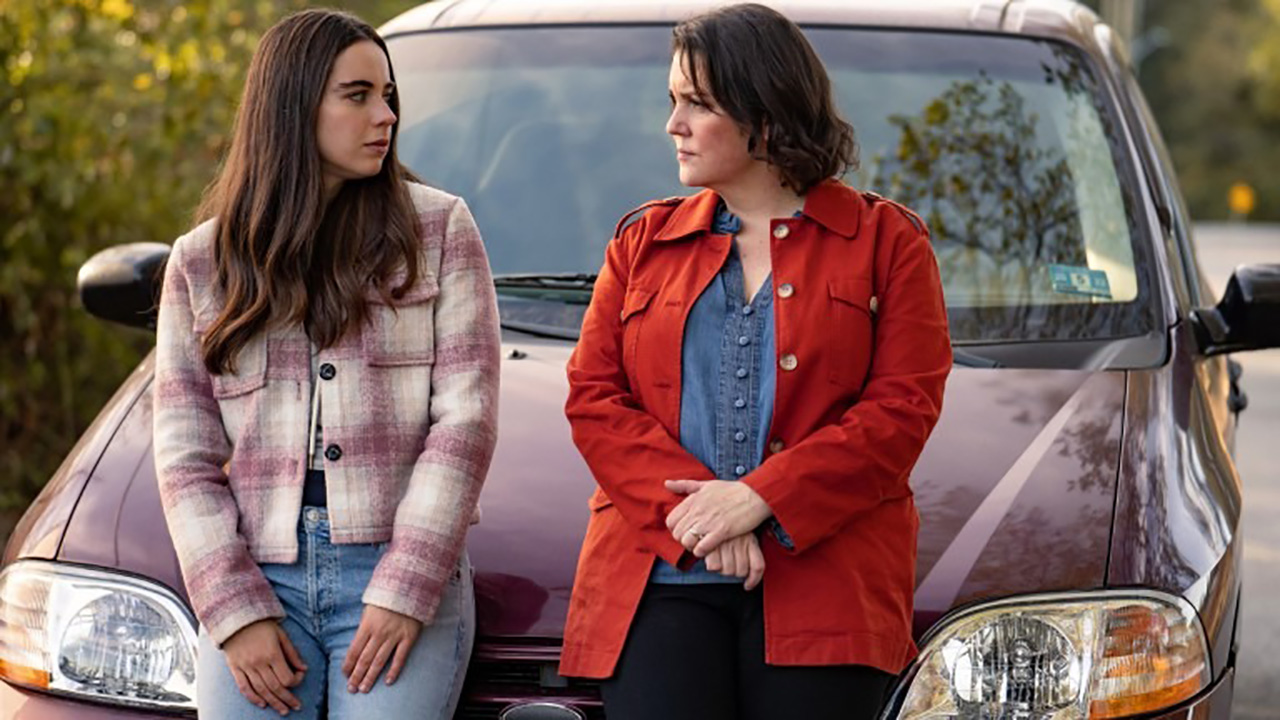 Callie and Shauna leaning against the car talking in a scene from Yellowjackets.