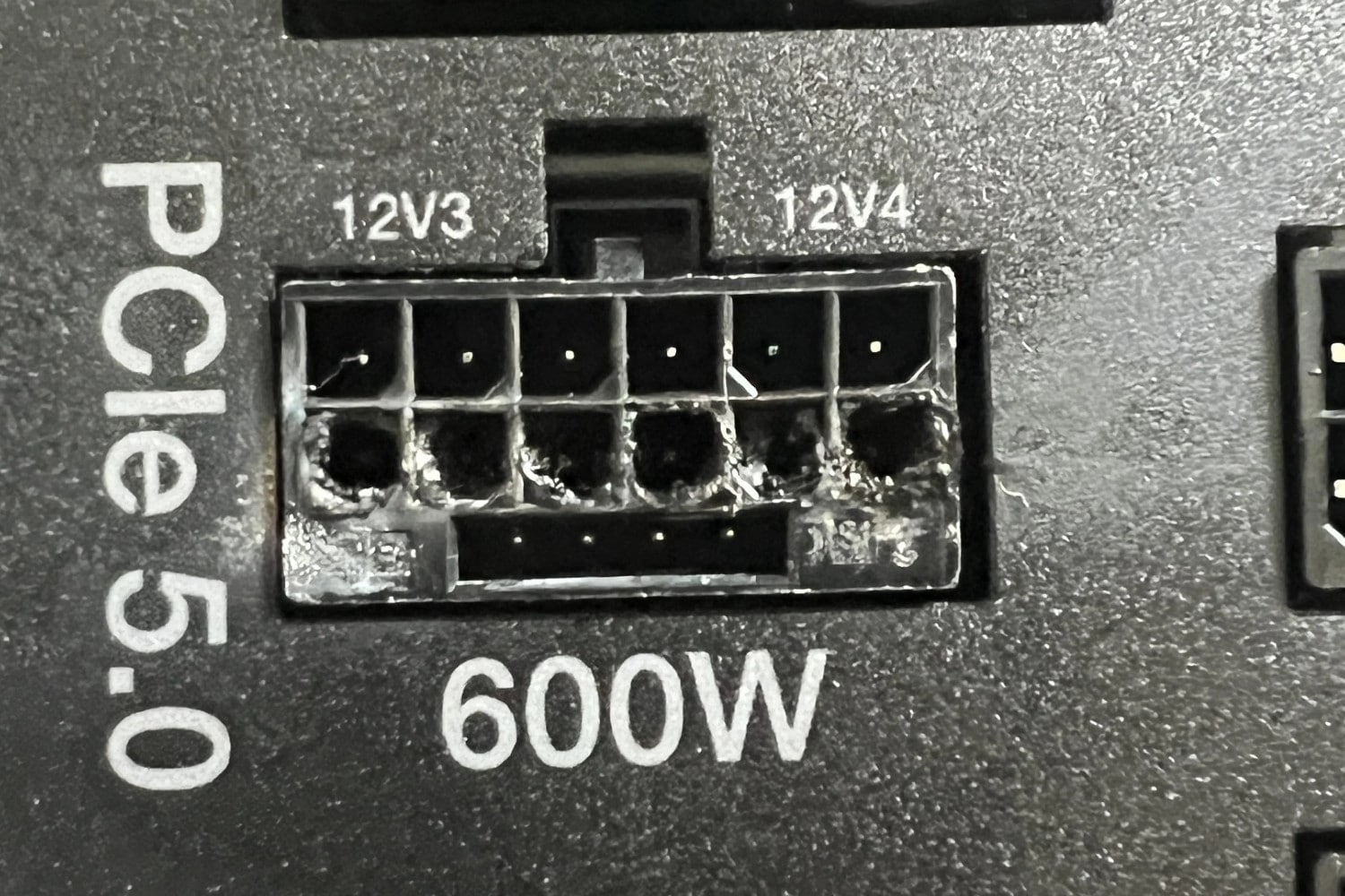The graphics card connectors on a power supply. The connectors are burned and melted from where an Nvidia 12VHPWR cable from an 