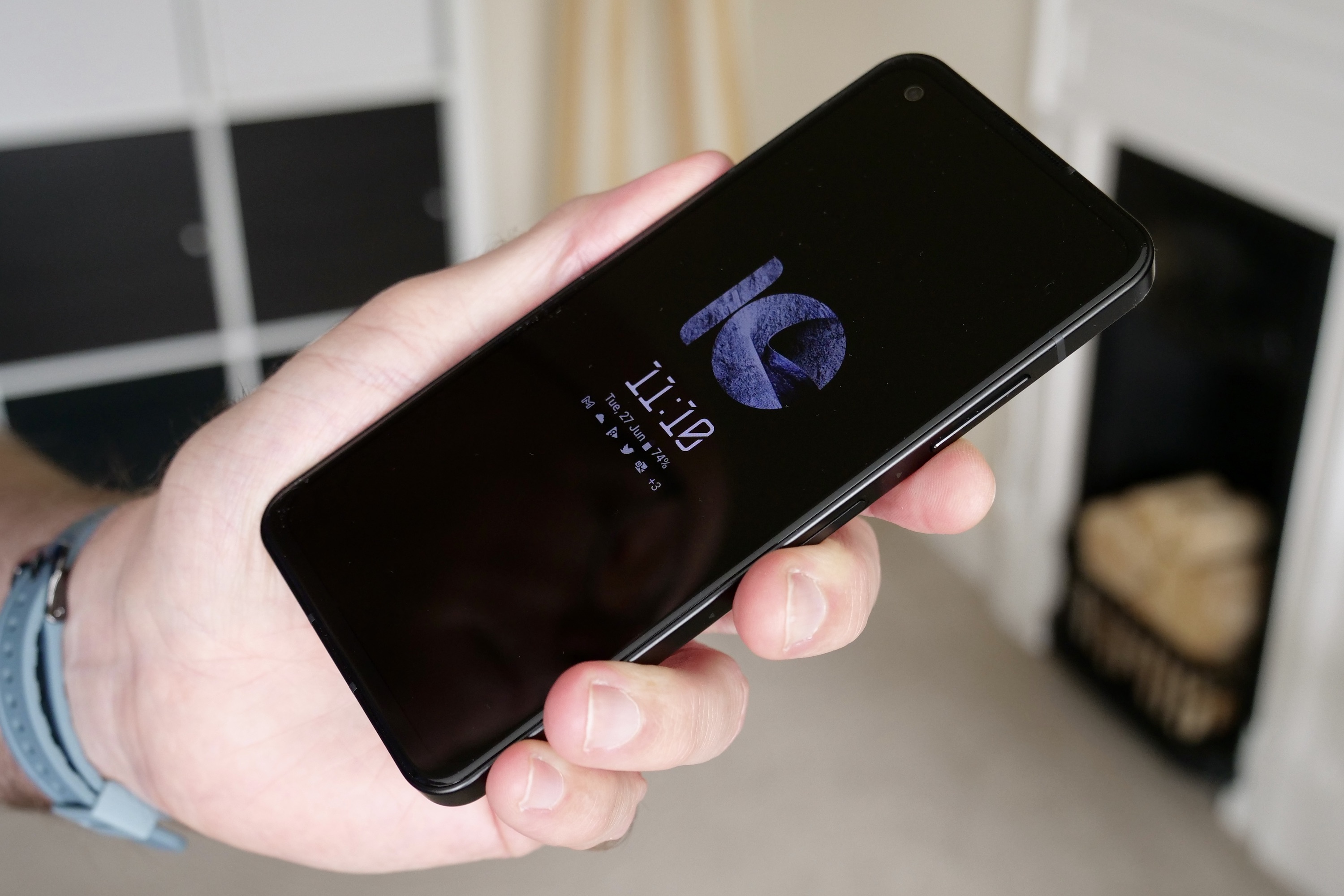 A person holding the Asus Zenfone 10 showing the always-on screen.