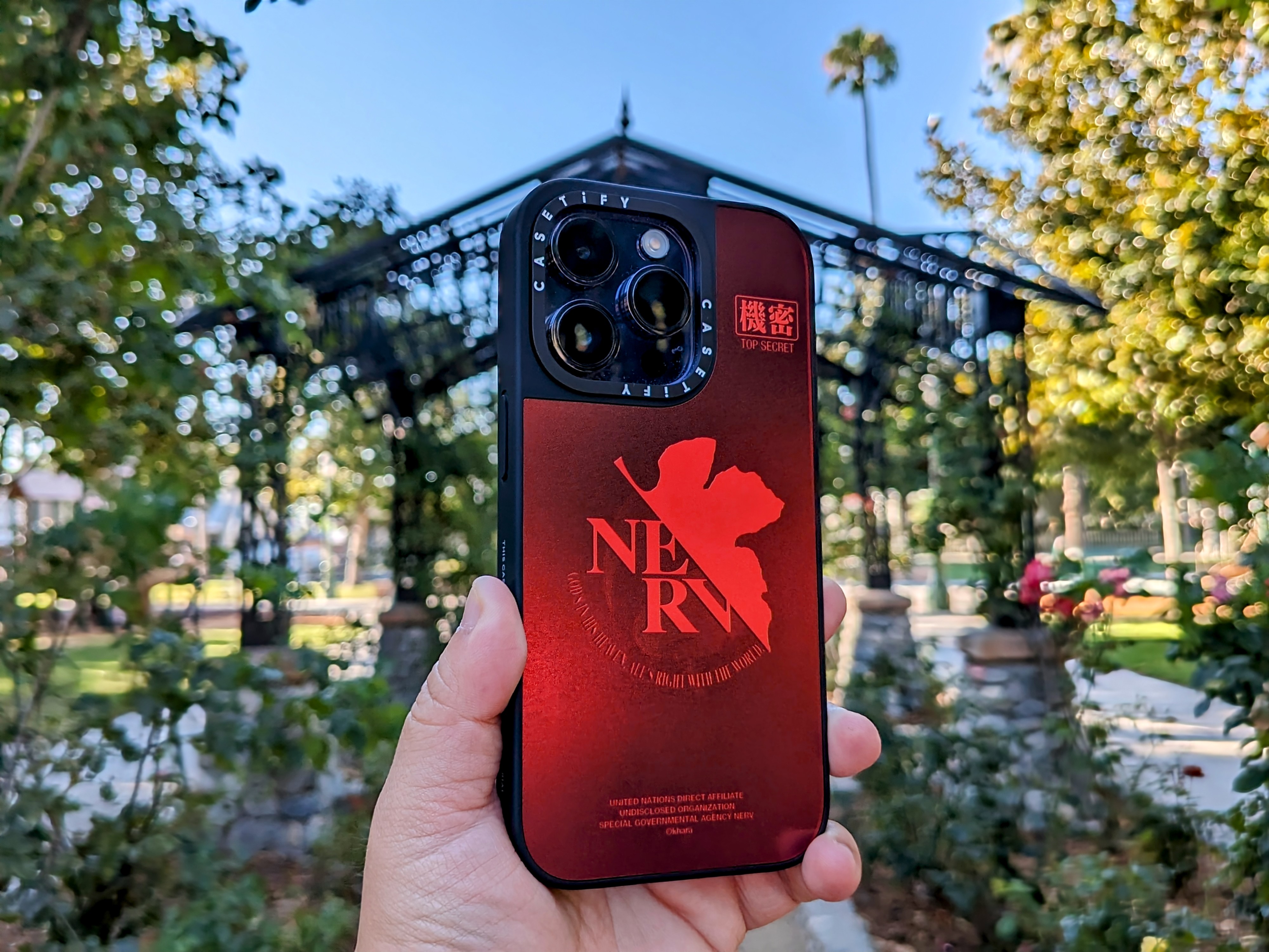 CASETiFY Evangelion NERV Mirror iPhone 14 Pro case in hand.