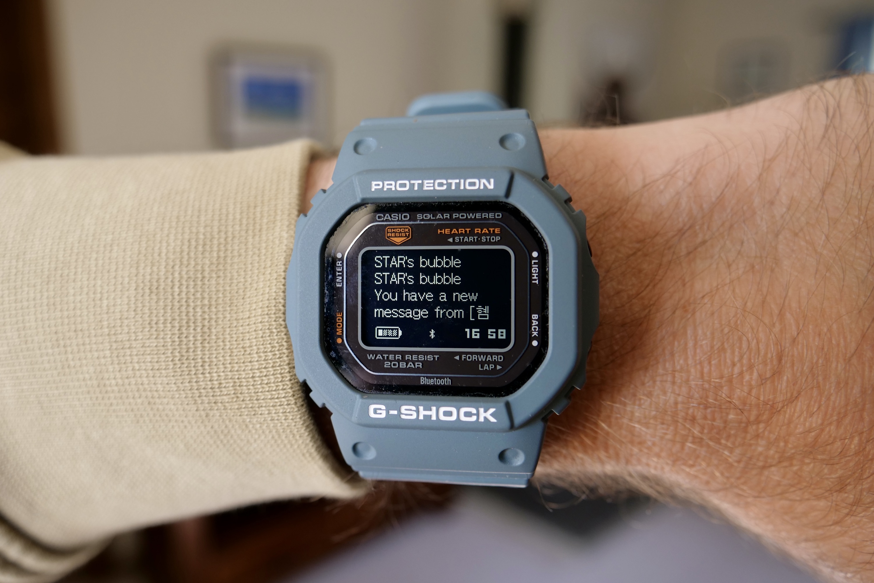A person wearing the Casio G-Shock DW-H5600, showing a notification.