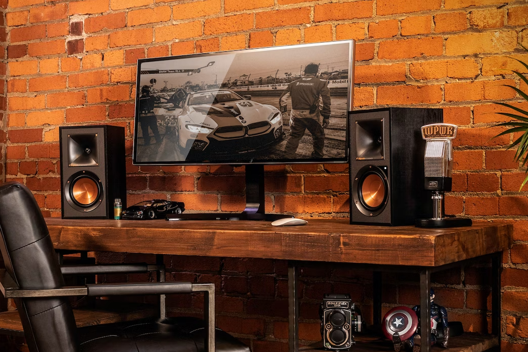 The Klipsch R-41PM Powered Bookshelf Speakers on a desk.