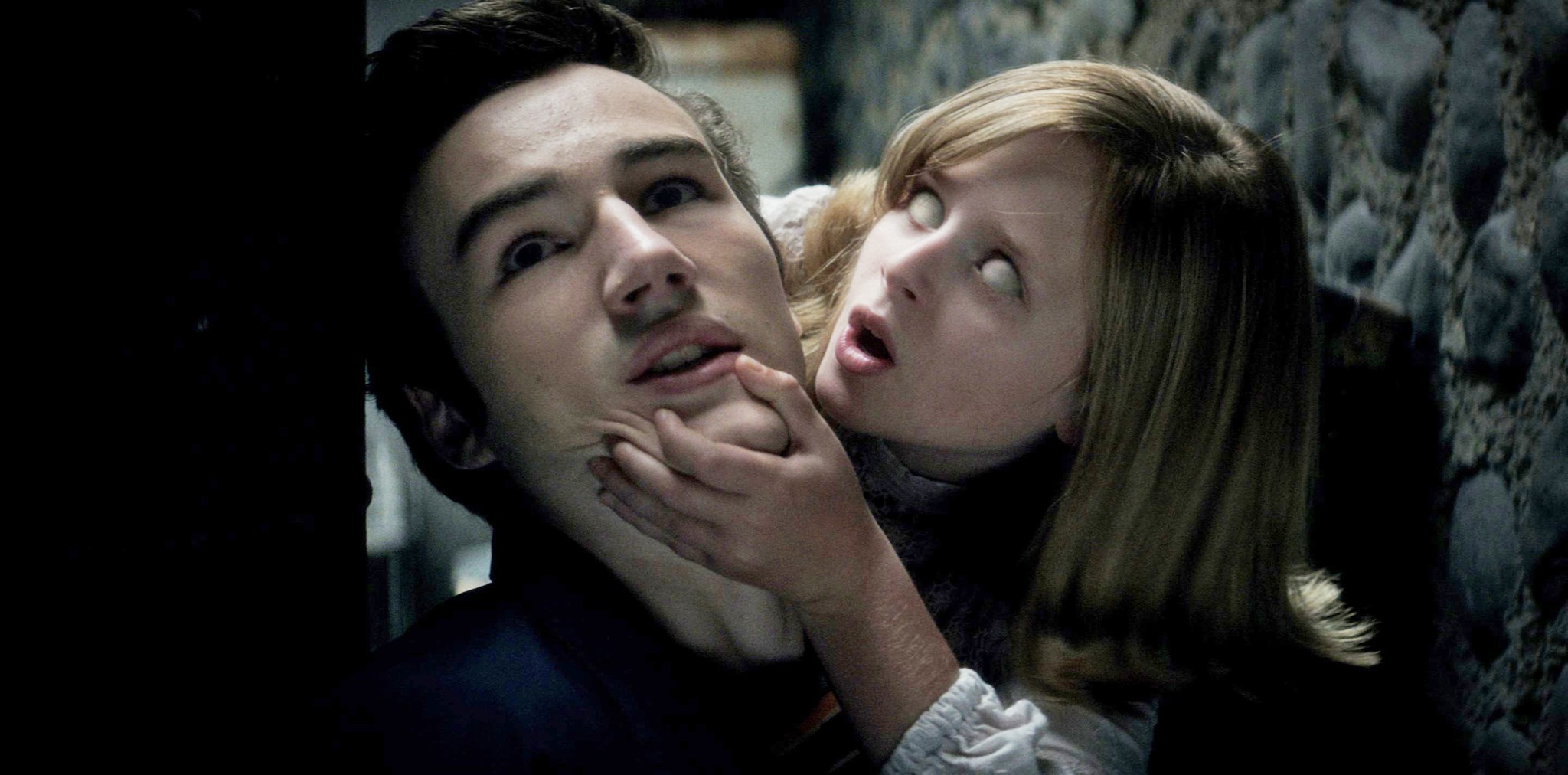 A possessed girl grabs a man in Ouija: Origin of Evil.